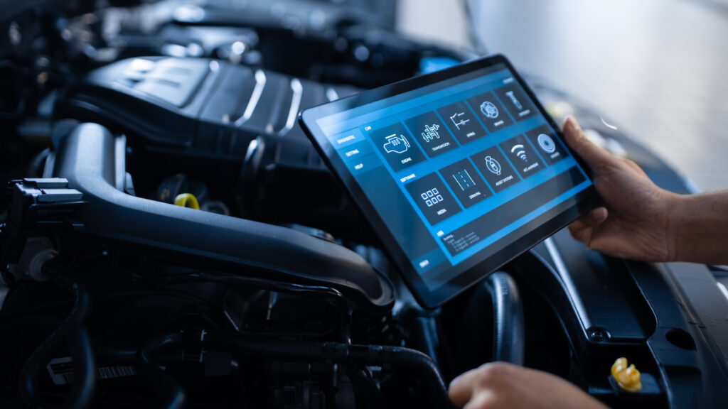 Car Service Manager or Mechanic Uses a Tablet Computer with a Futuristic Interactive Diagnostics Software Specialist Inspecting the Vehicle in Order to Find Broken Components In the Engine Bay